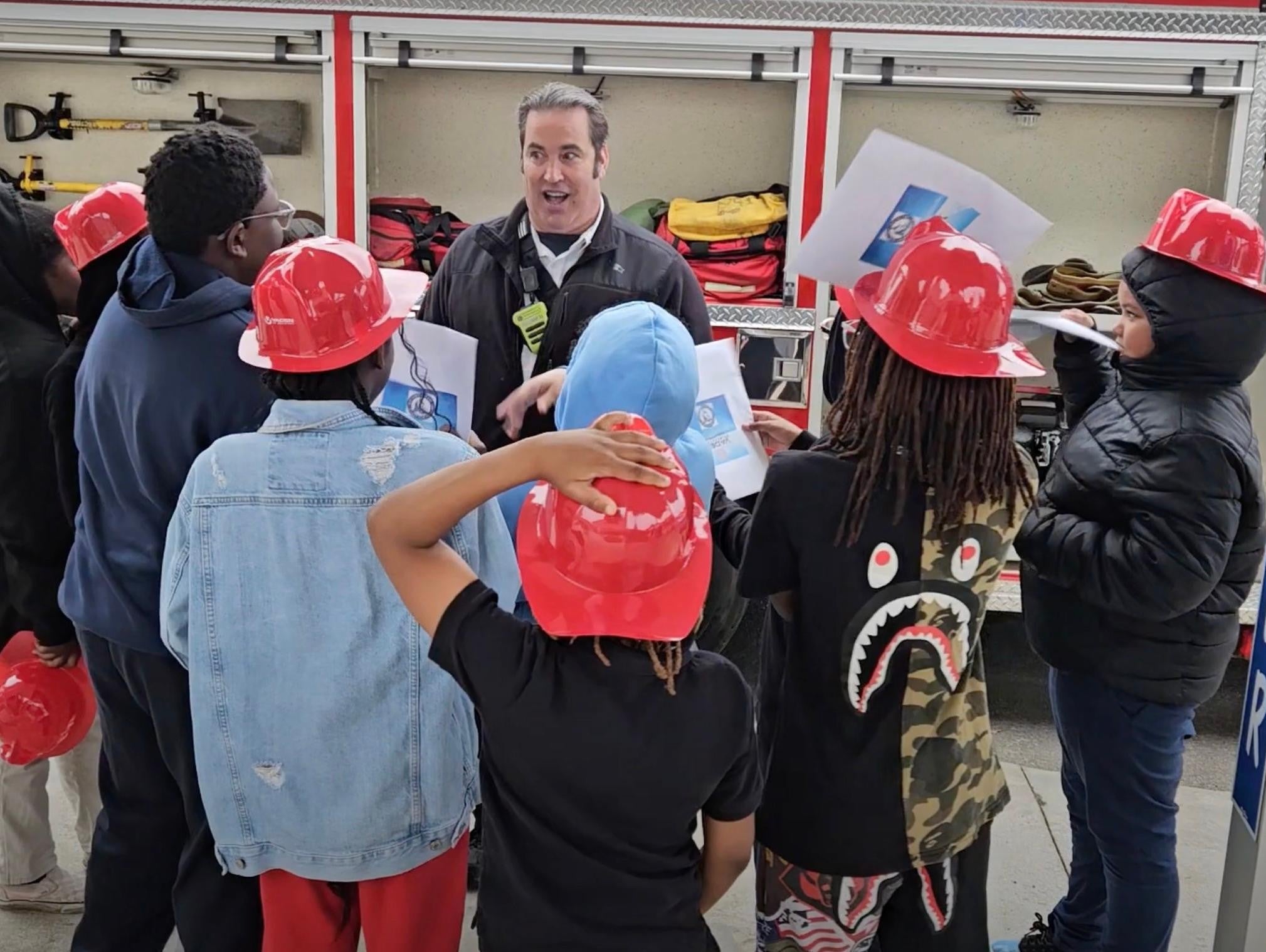 A firefighter talking to a group of children