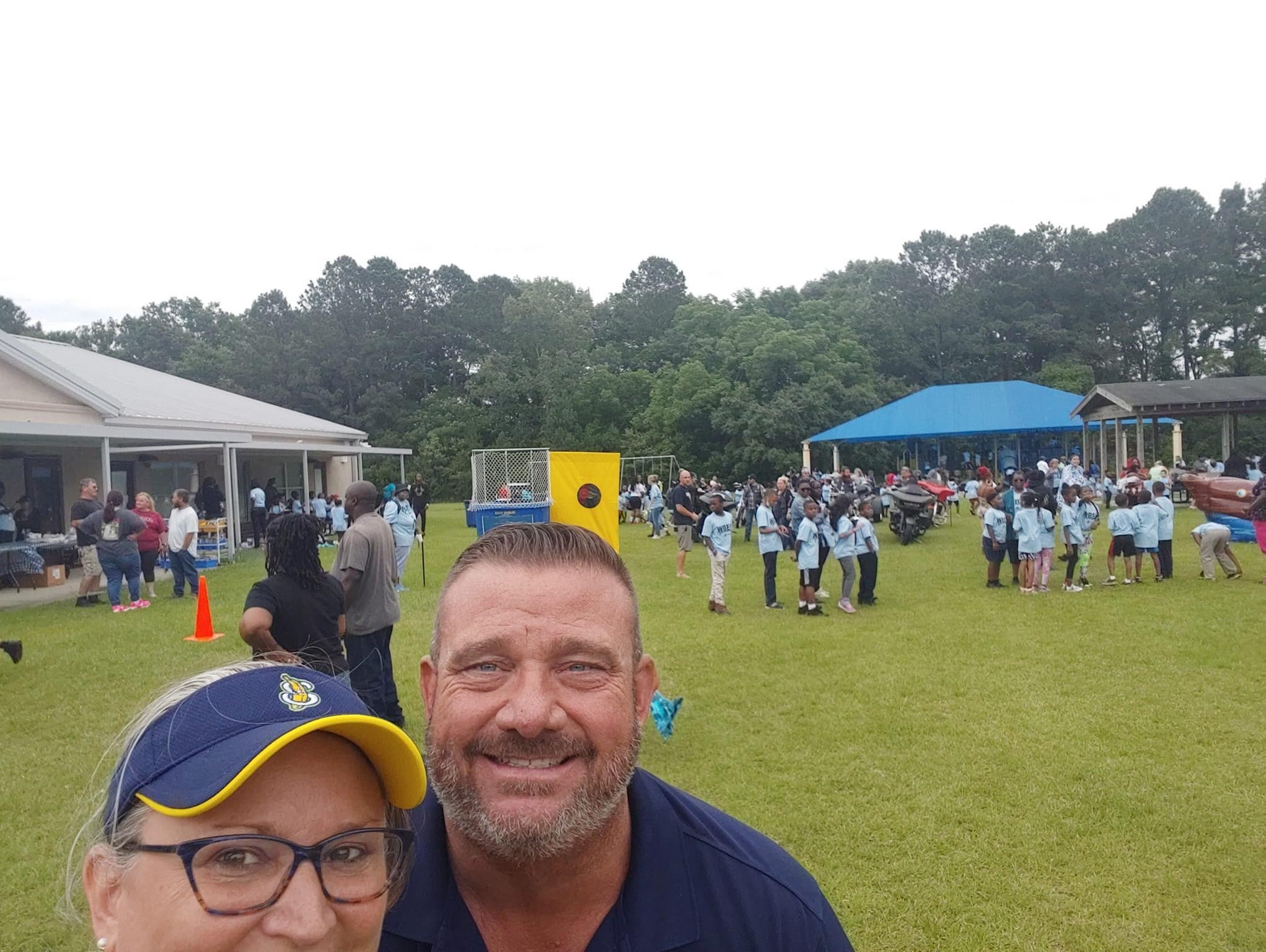 A selfie of two people at an event in a park